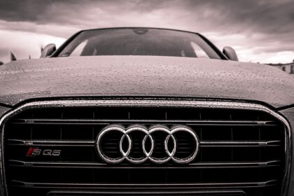 Αυτοκίνητο Audi στον δρόμο υπό βροχή με τον σήμερα της εταιρείας στον προφυλακτήρα