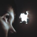 Μικρό παιδί κοιτάζει μέσα από τρύπα σε χαρτόνι