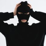 Νεαρός με στολή ληστή και κουκούλα πιάνει το κεφάλι του