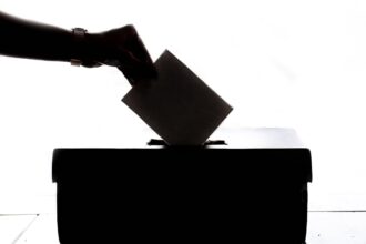 Χέρι ρίχνει ψήφο σε κάλπη, συμβολισμός της δημοκρατίας