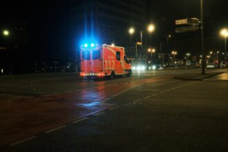 Tram stopped on tracks in Munich during night with rescue vehicles nearby