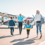 German family with children at airport preparing for summer holiday trip
