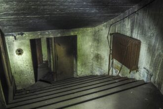 Reinforced bunker door in a basement designed as protective shelter