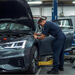 Mechanic working on car in German repair shop as insurance costs rise