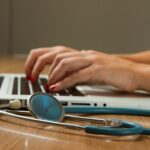 Doctor at laptop with digital health record in Germany