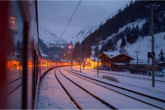 Night train arriving in a snowy Alpine town during winter