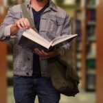 Student with a book at the library of LMU university at Munich