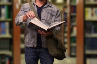 Student with a book at the library of LMU university at Munich
