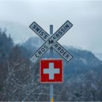 Swiss border sign covered in snow symbolising new asylum travel restrictions