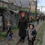 German and EU flags in front of the Reichstag, symbolizing Germany’s new role in EU migration reform.