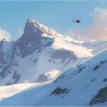 Rescue helicopter flying above a snowy mountain ridge in the Ortler Alps in South Tyrol