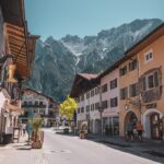 Παραδοσιακά σπίτια με τοιχογραφίες Lüftlmalerei στο κέντρο του Mittenwald με φόντο τις Άλπεις